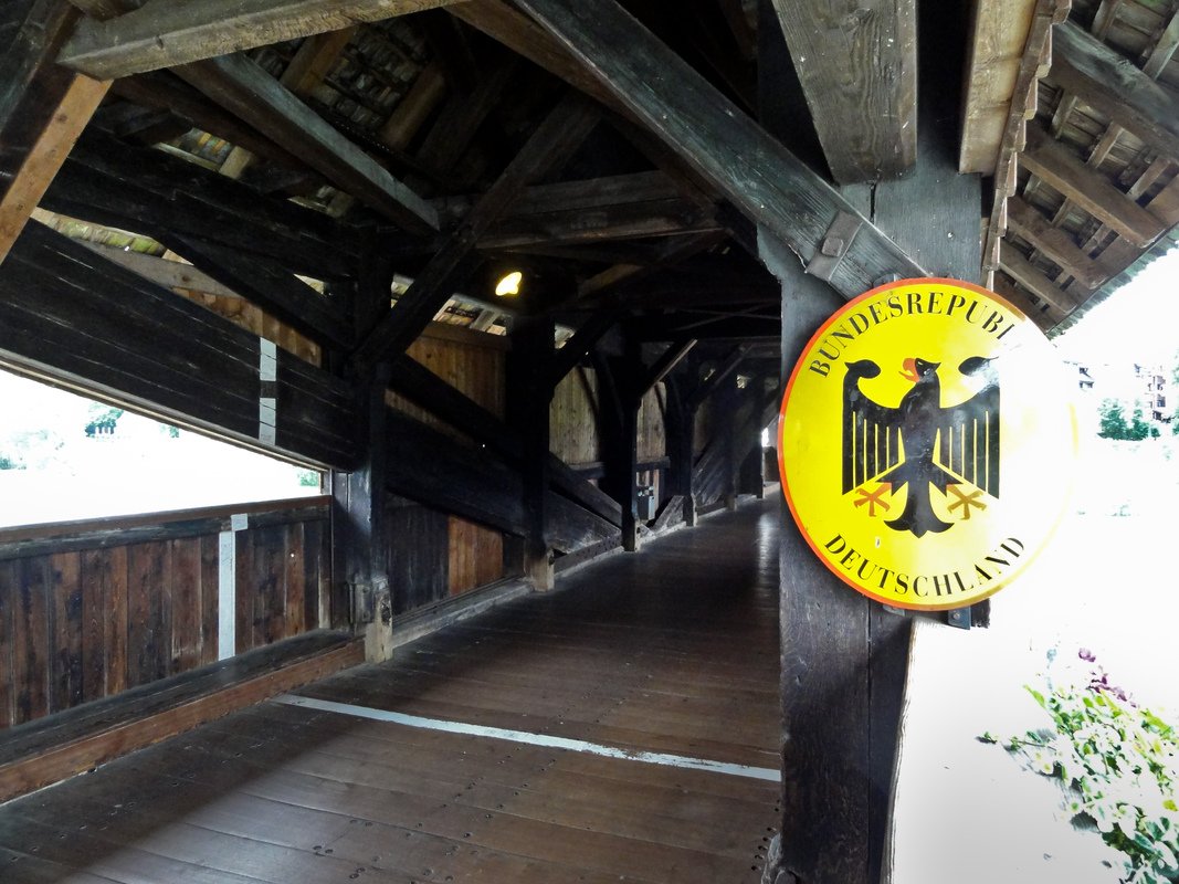 Holzbrücke Bad Säckingen— Grenze zwischen der Bundesrepublik Deutschland und der Schweizer Eidgenossenschaft: Grenzmarkierung oberhalb der der Rheinmitte (weiße Linie) mit ovalem Schild "Bundesrepublik Deutschland".