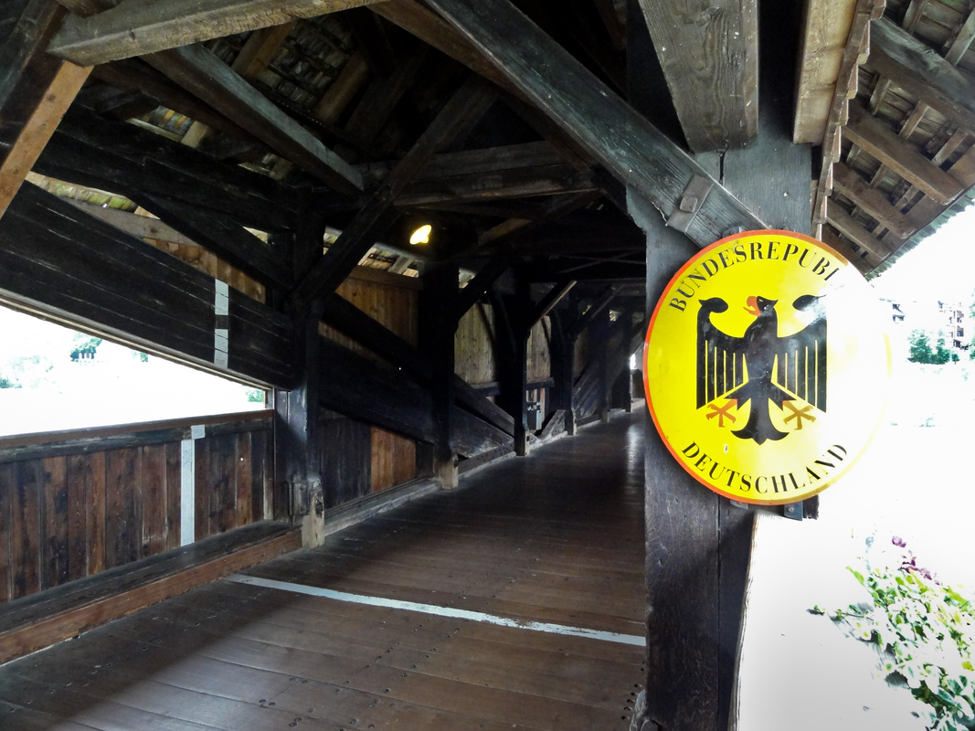 Holzbrücke Bad Säckingen— Grenze zwischen der Bundesrepublik Deutschland und der Schweizer Eidgenossenschaft: Grenzmarkierung oberhalb der der Rheinmitte (weiße Linie) mit ovalem Schild "Bundesrepublik Deutschland".