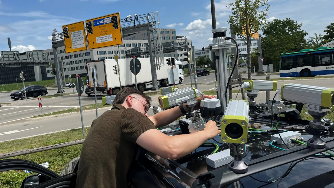 TUM-Forscher Erik Leo Haß prüft die Sensorik auf dem Fahrzeug an einer Kreuzung in Garching-Hochbrück. Bild: Schmitz / TUM